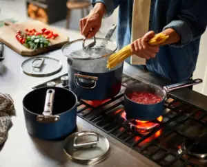 Blue ceramic non-stick 15cm saucepan with folding handle and lid by Joseph Joseph, displayed on a modern kitchen countertop
